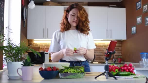 Junge Frau zu Hause in Küche erzählt Rezept vor der Kamera. — Stockvideo