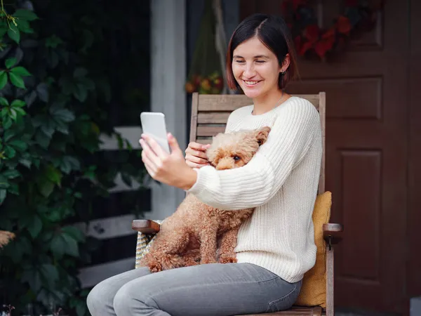 Sonriente mujer con perro al aire libre haciendo selfie —  Fotos de Stock