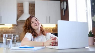 Kadın arkadaşıyla uzaktan sohbet etmek için laptop video uygulaması kullanıyor.