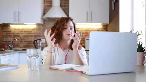 Mujer saluda y habla con el chat de vídeo utilizando el ordenador portátil. — Vídeo de stock