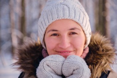 Mutlu Asyalı kadın kar ormanlarında yürüyor.