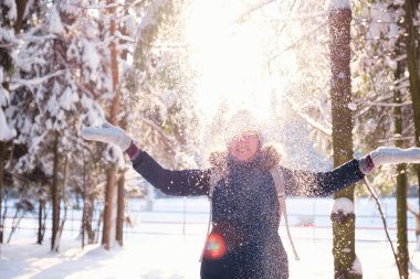 Mutlu Asyalı kadın kar ormanlarında yürüyor.