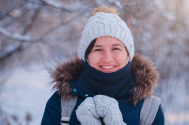 Mutlu Asyalı kadın kar ormanlarında yürüyor.