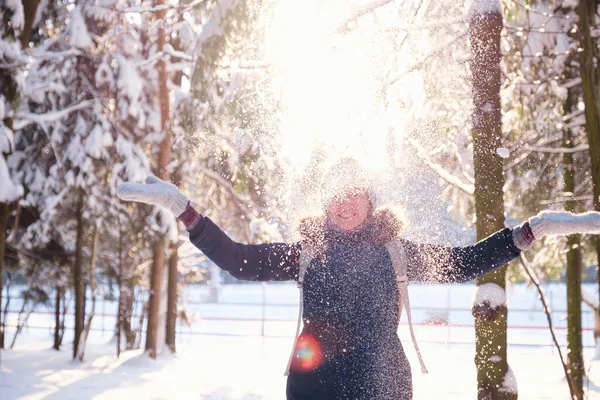 Mutlu Asyalı kadın kar ormanlarında yürüyor.