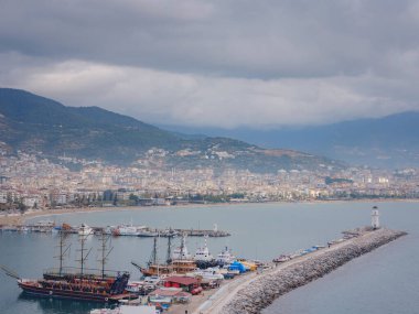 Alanya, hindi, Akdeniz kıyısında kış yürüyüşü. Ariel, Alanya Yarımadası 'ndan Alanya Limanı manzaralı. Kış gününe kadar Türk Rivierası. Güzel bir şehir manzarası. Türk tatil beldesi.