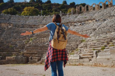 Sıcak Ekim öğleden sonra Antalya 'da yürüyüş. Eski Perge şehrinin kalıntılarında sırt çantalı güzel bir turist kadın.