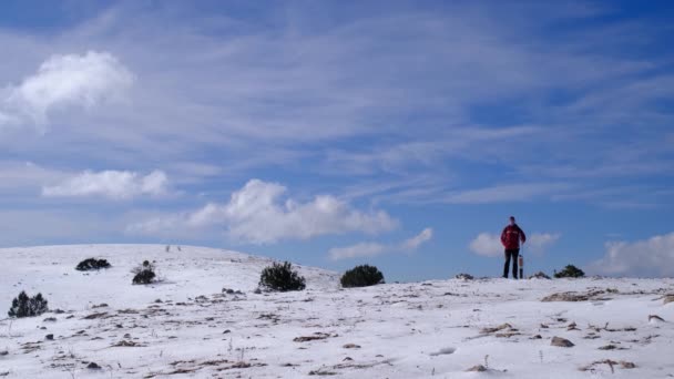 Alpinista atinge o topo da montanha nevada no dia ensolarado de inverno. — Vídeo de Stock