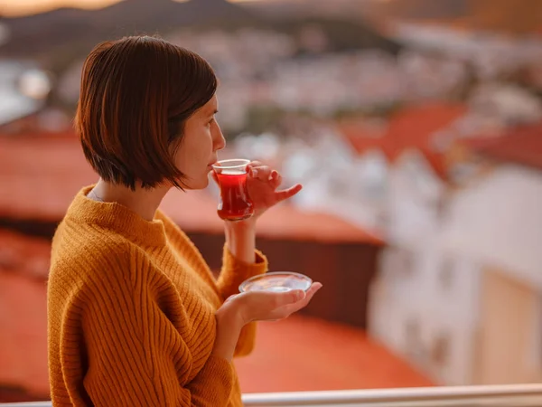 Woman drinking turkish tea from traditional turkish teacup