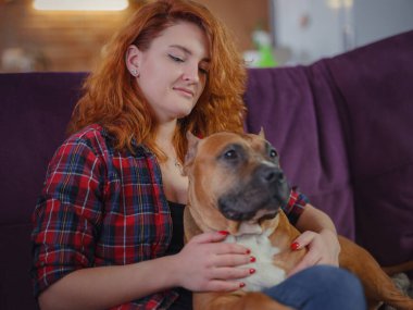 Mutlu kadın, evdeki oturma odasındaki koltukta Amerikan personeli teriyerini okşuyor.