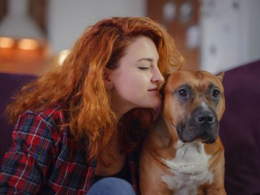 Mutlu kadın, evdeki oturma odasındaki koltukta Amerikan personeli teriyerini okşuyor.