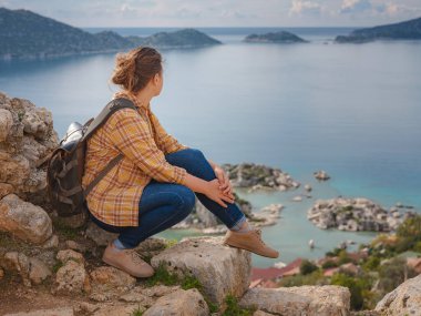 Türkiye 'nin Kekova adasında seyahat ve turistik merkezler. Kadın gezgin Simena Kalesi 'ni deniz körfezi ve Kekova Adası' nın ünlü taşkın şehri manzarasıyla keşfeder. Türkiye 'de turistik merkezler.