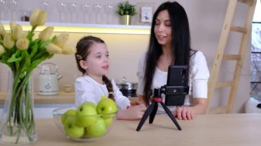 Blogcu anne ve bebeği evde. Millennial Influencer kadını annelik blogu için içerik yaratıyor, sosyal ağ için çevrimiçi hikayeler kaydediyor, video platformuna blog yazıyor