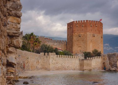 Alanya, hindi, Akdeniz kıyısında kış yürüyüşü. Alanya yarımadasındaki Kizil Kule kulesi. Yüksek dağları olan ünlü bir turizm merkezi. Eski bir şatonun parçası.