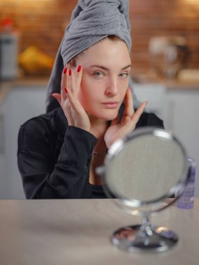 Profesyonel kozmetik ürün sonuçlarından, günlük etkili cilt bakımından, cilt bakımı konseptinden memnun genç ve mutlu bir kadın.