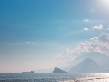 Kargo gemisi sakin mavi Akdeniz 'de, Anatalya' da. Akdeniz boyunca seyahat etmek, Antalya 'nın kayalık kıyılarını görmek. Uzakta, kargo gemileri görünüyor..