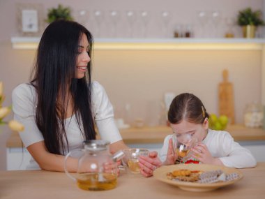 Evde mutfakta kurabiye ile çay içen bir aile..