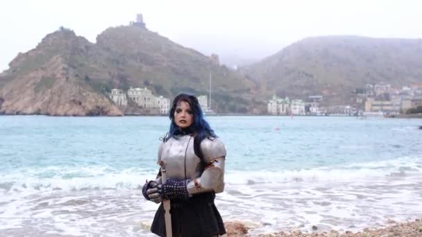 Vrouw krijger in harnas tegen fort op rots en zee — Stockvideo