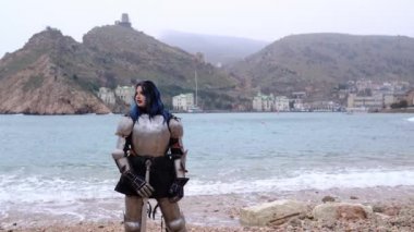 Zırhlı kadın savaşçı kaya ve denizdeki kaleye karşı.