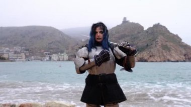 Zırhlı kadın savaşçı kaya ve denizdeki kaleye karşı.