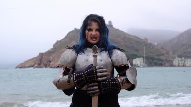 Woman warrior in armor against fortress on rock and sea — Stock Video