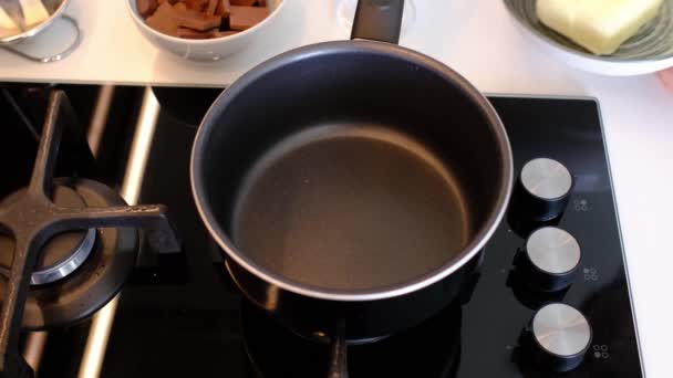 ガスストーブの上の鍋にバターの一片を溶融し、混合,バターは液体になる. — ストック動画