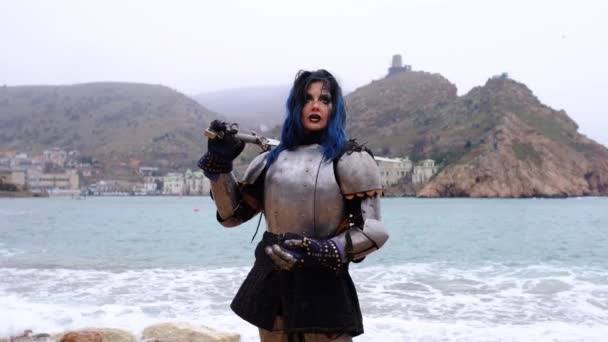 Vrouw krijger in harnas tegen fort op rots en zee — Stockvideo