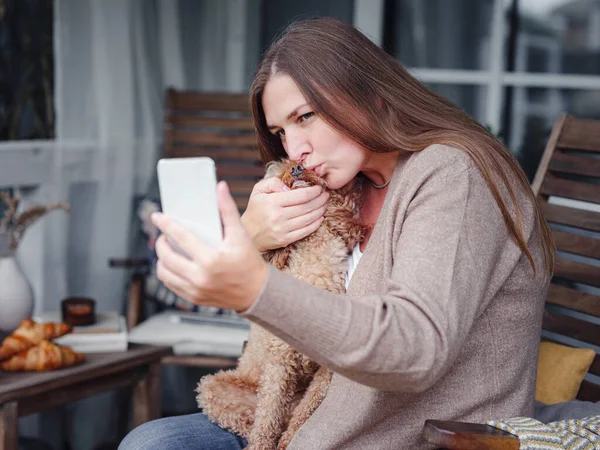 Sonriente mujer con perro al aire libre haciendo selfie —  Fotos de Stock