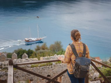Türkiye 'nin Kekova adasında seyahat ve turistik merkezler. Kadın gezgin Simena Kalesi 'ni deniz körfezi ve Kekova Adası' nın ünlü taşkın şehri manzarasıyla keşfeder. Türkiye 'de turistik merkezler.