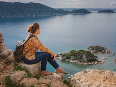 Türkiye 'nin Kekova adasında seyahat ve turistik merkezler. Kadın gezgin Simena Kalesi 'ni deniz körfezi ve Kekova Adası' nın ünlü taşkın şehri manzarasıyla keşfeder. Türkiye 'de turistik merkezler.