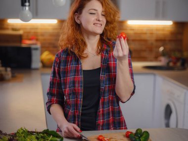 Happy smiling cute woman cooking fresh healthy vegan vegetable salad at home in kitchen and trying new recipe. Nutrition For Slimming, Weight Loss Food Recipes Concept
