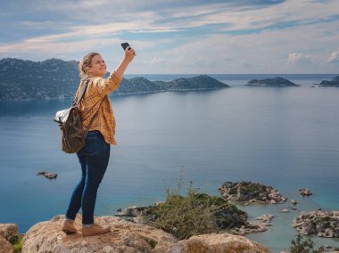 Türkiye 'nin Kekova adasında seyahat ve turistik merkezler. Kadın gezgin Simena Kalesi 'ni deniz körfezi ve Kekova Adası' nın ünlü taşkın şehri manzarasıyla keşfeder. Türkiye 'de turistik merkezler.