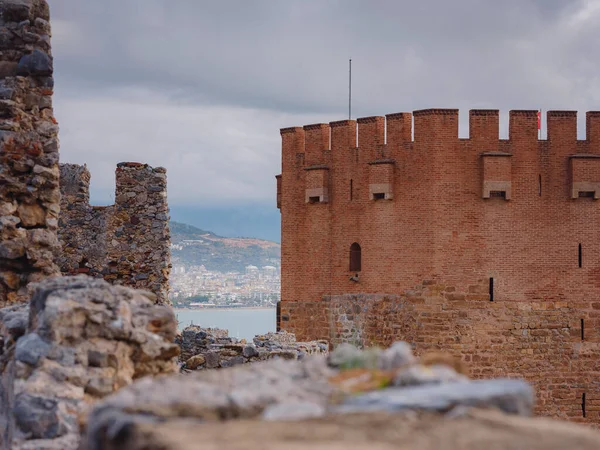 Alanya, hindi, Akdeniz kıyısında kış yürüyüşü. Alanya yarımadasındaki Kizil Kule kulesi. Yüksek dağları olan ünlü bir turizm merkezi. Eski bir şatonun parçası.