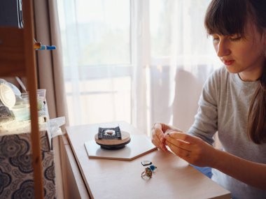 Hayat tarzı konsepti, evden çalışmak hayatını yeniden keşfetmek - mücevher tasarımcısı işyeri. Kadın mücevher yapar. Gürcistan minankari emaye üretim tekniği. Kuyumcu atölyede aksesuar yapıyor..