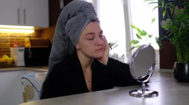 Kadın, deri hastalığıyla ilgili sorunlar ararken mini ayna ile şoka giriyor. Kadın yüzünde akne ve problem derisinin kavramsal görüntüsü.