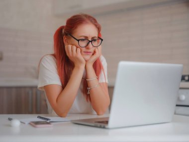 Evde bilgisayarla çalışan mutlu, genç bir bayan serbest yazar. Çevrimiçi bilgisayar yazılımı, web sörf bilgisi ya da online alışveriş kullanan çekici bir kadın.