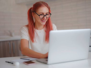 Evde bilgisayarda çalışan serbest çalışan, ders dinlerken ya da webinar dinlerken deftere notlar alan biri. İnternette bilgisayar yazılımı, internet sörfü ya da online alışveriş yapan çekici bir kadın..