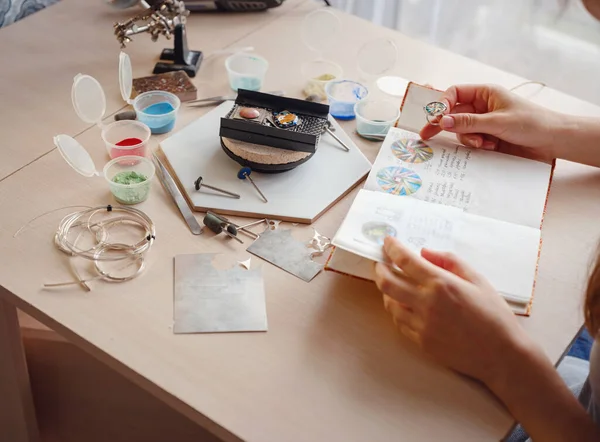 Hayat tarzı konsepti, evden çalışmak hayatını yeniden keşfetmek - mücevher tasarımcısı işyeri. Kadın mücevher yapar. Gürcistan minankari emaye üretim tekniği. Kuyumcu atölyede aksesuar yapıyor..