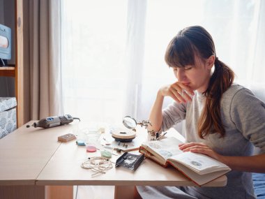 Hayat tarzı konsepti, evden çalışmak hayatını yeniden keşfetmek - mücevher tasarımcısı işyeri. Kadın mücevher yapar. Gürcistan minankari emaye üretim tekniği. Kuyumcu atölyede aksesuar yapıyor..