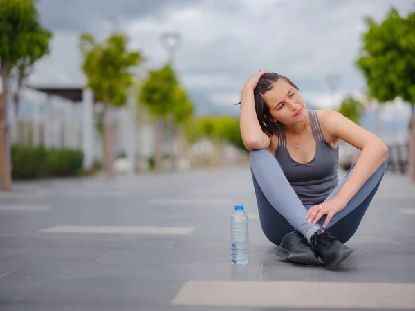 outdoor sports, workout and wellness concept. asian young strong, confident woman in sportive clothes Relaxing After Fitness Workout In Park. Female runner taking break from running sport.