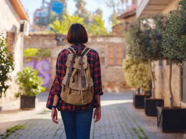 Türkiye 'ye, eski Antalya Kaleci ilçesine, ünlü turizm beldesine gitmek. Mutlu Asyalı bayan turist sırt çantalı gezgin eski şehirde yürüyor..
