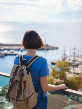 Türkiye 'ye, eski Antalya Kaleci' ye. Eski şehirde sırt çantalı mutlu Asyalı turist kadın yürüyüşçüler. Eski kasabayı ve limanı gözetleyen bir kadın var.