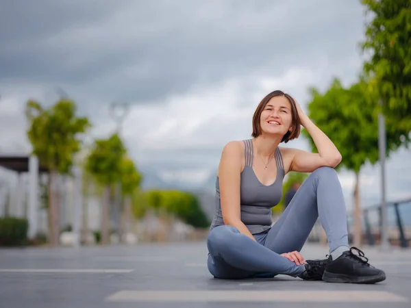 outdoor sports, workout and wellness concept. asian young strong, confident woman in sportive clothes Relaxing After Fitness Workout In Park. Female runner taking break from running sport.