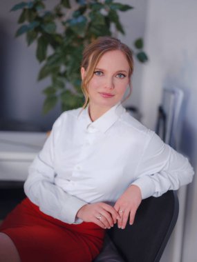 Ofiste çalışırken dizüstü bilgisayardan yaratıcı fikirler hakkında ders kitabı izleyen başarılı bir kadın grafik tasarımcısı. Sarı saçlı pozitif öğrenci internet üzerinden iş haberleri okuyor.