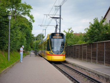 Basel, İsviçre - 4 Temmuz 2022: Şehirde toplu taşıma. Banliyö sarı treni, yaz günü durakta.