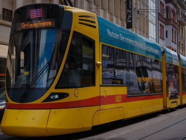 Basel, İsviçre - 4 Temmuz 2022: Şehirde toplu taşıma. Basel şehir merkezindeki yeşil tramvay. Basel 'in yeşil ve sarı tramvayları şehrin ayrılmaz bir parçası haline geldi..