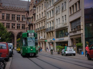 Basel, Switzerland - July 4 2022: public transport in the city. Green tram in street of Basel city center. Basels green and yellow trams have become an inseparable part of the cityscape.