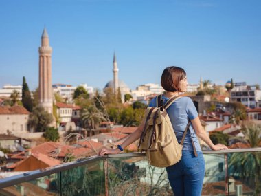 Türkiye 'ye, eski Antalya Kaleci' ye. Eski şehirde sırt çantalı mutlu Asyalı turist kadın yürüyüşçüler. Eski kasabayı ve limanı gözetleyen bir kadın var.