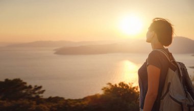 Travel to Turkey, viewpoint over Dalyan Iztuzu Beach. . Smiling woman taking break on hiking trip looking at view at sunset. Explore natural wonders of Turkey
