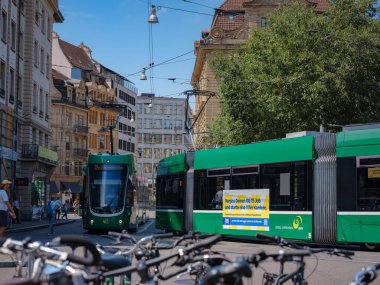 Basel, Switzerland - July 4 2022: public transport in the city. Green tram in street of Basel city center. Basels green and yellow trams have become an inseparable part of the cityscape.