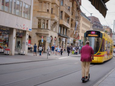 Basel, Switzerland - July 4 2022: public transport in the city. Green tram in street of Basel city center. Basels green and yellow trams have become an inseparable part of the cityscape.